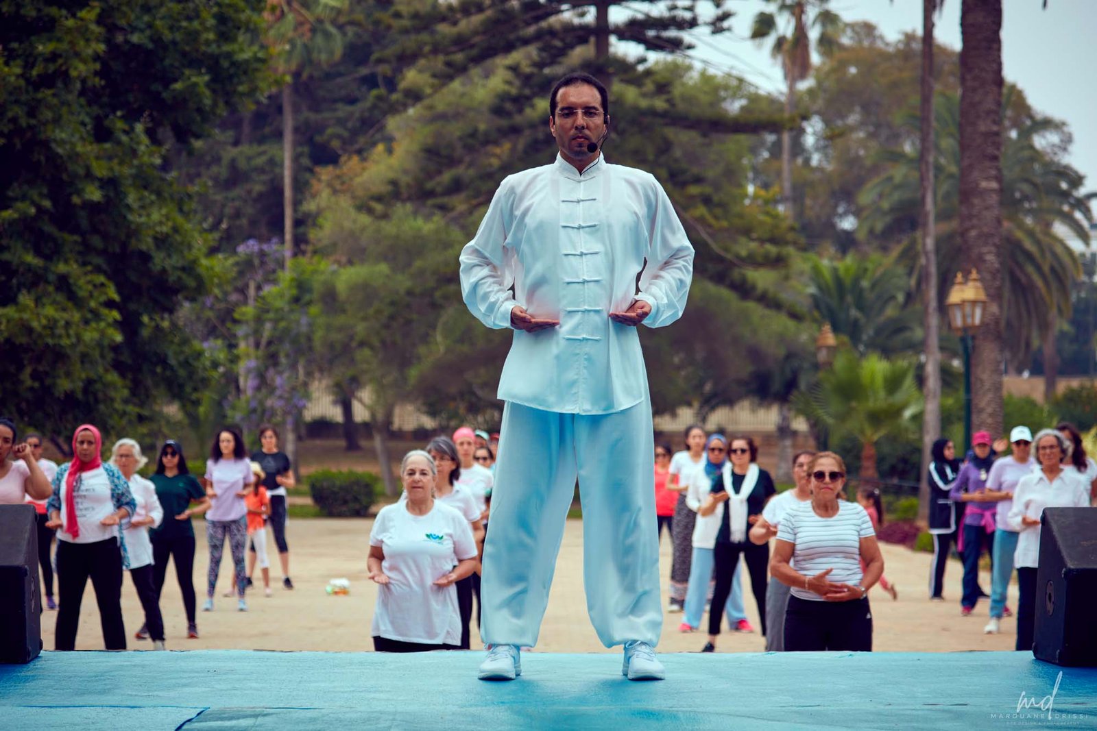 L’enseignant de l’institut guide une séance de Qigong en plein air, les pratiquants derrière lui